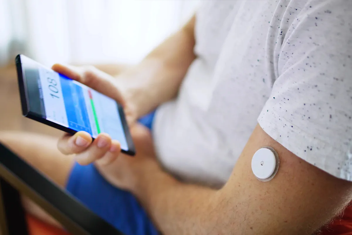 Image of a man monitoring his blood glucose levels via a Smartphone app